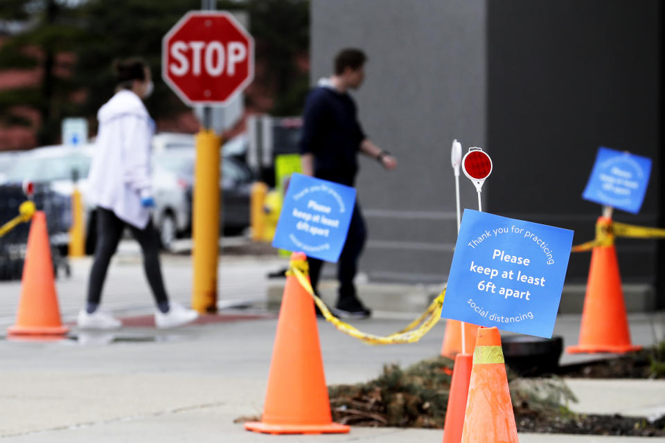 FILE - In this Saturday, April 4, 2020 file photo, information signs are posted in front of an entrance at a Walmart store in Vernon Hills, Ill. On Friday, April 10, 2020, The Associated Press reported on stories circulating online incorrectly asserting that due to the COVID-19 pandemic, effective immediately, Walmart is adopting a staggered shopping schedule based on age. Walmart is offering special hours for seniors but has not designated times for people to shop by age group. (AP Photo/Nam Y. Huh)