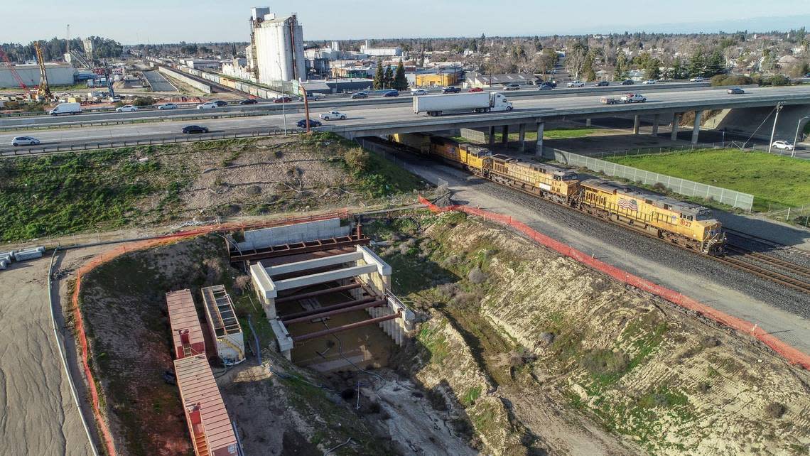 Highway 180 passes over a tunnel constructed for the California High-Speed Rail project next to the railroad tracks near G Street in Fresno on Friday, Feb. 17, 2023.