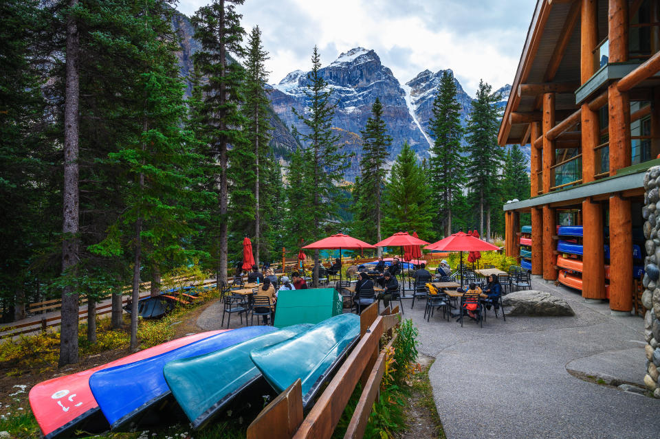 Moraine Lake, Alberta, Canada - September 25, 2021 : Moraine Lake Cafe in Banff National Park with snow-covered peaks of canadian Rocky Mountains in the background and kayaks in the foreground.