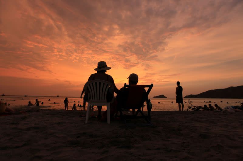 FILE PHOTO: Tourists watch the sunset at El Rodadero beach, near the Caribbean port of Santa Marta, in Rodadero