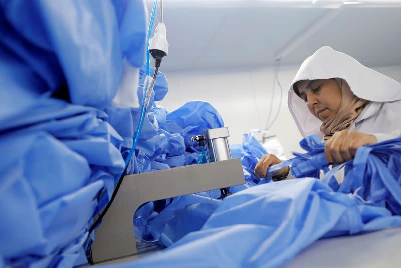 A woman sews coats in a factory that produces sterilised surgical equipment and medical clothings in Egypt