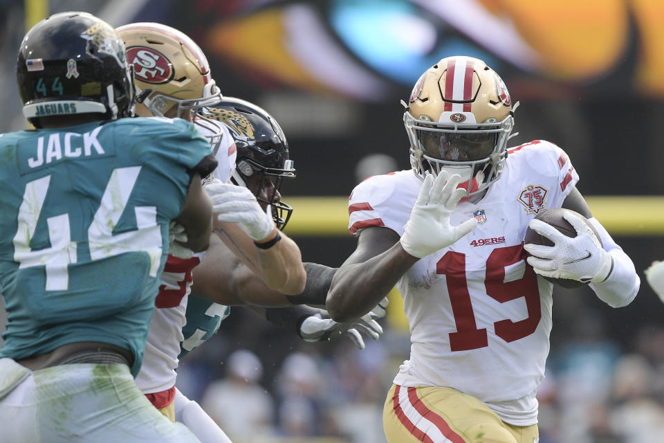 San Francisco 49ers wide receiver Deebo Samuel (19) runs past Jacksonville Jaguars linebacker Myles Jack (44) during the first half of an NFL football game, Sunday, Nov. 21, 2021, in Jacksonville, Fla. (AP Photo/Phelan M. Ebenhack)