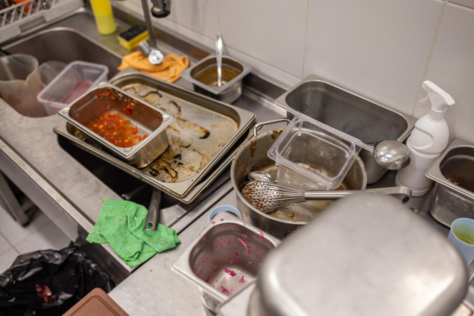 dirty pile of kitchen pans and pots