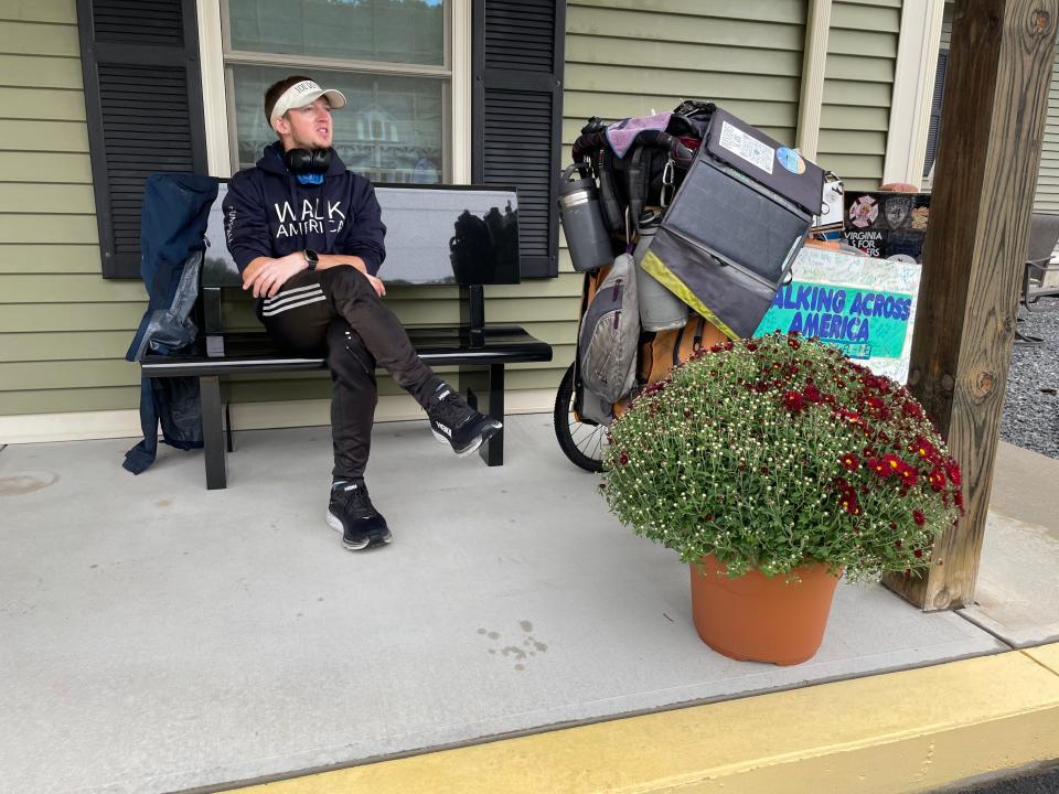 Provo, Utah resident Isaiah Glen Shields waits for the rain to stop, while on the patio of Mercer Monument Works in Plainfield. He has been on a trip to walk the width of the United States by foot since May 2021.
(Photo: Matt Grahn)