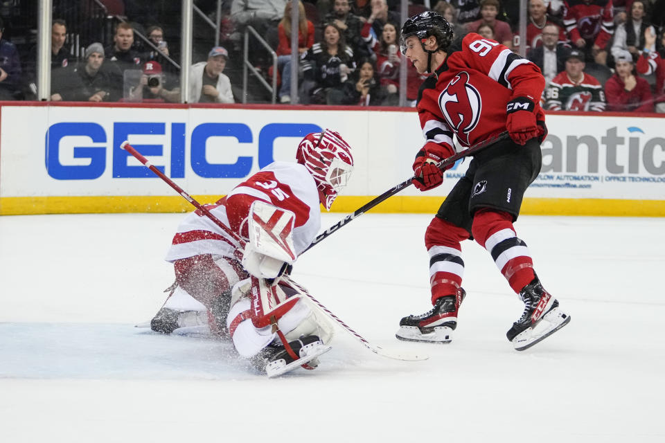 Detroit Red Wings goaltender Ville Husso (35) stops a shot by New Jersey Devils' Dawson Mercer (91) during the second period of an NHL hockey game Thursday, Oct. 12, 2023, in Newark, N.J. (AP Photo/Frank Franklin II)