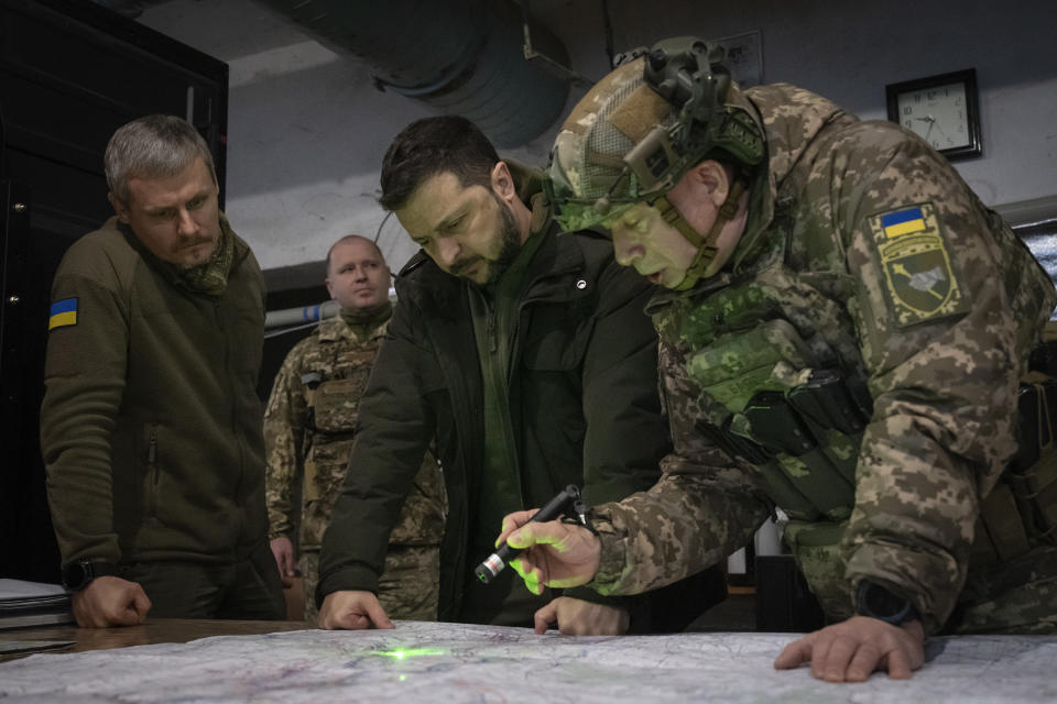 FILE - Ukrainian President Volodymyr Zelenskyy, Commander of Ukraine's Ground Forces Col.-Gen. Oleksandr Syrsky, right, and Roman Mashovets, deputy head of the Presidential Office, look at a map during their visit to the front line city of Kupiansk, Kharkiv region, Ukraine, Thursday, Nov. 30, 2023. A gloomy mood hangs over Ukraine’s soldiers nearly two years after Russia invaded their country. Ukrainian soldiers remain fiercely determined to win, despite a disappointing counteroffensive this summer and signs of wavering financial support from allies. (AP Photo/Efrem Lukatsky, File)