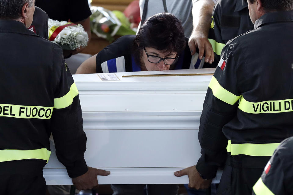 A woman kisses the coffin of 9-year-old Giulia Rinaldo