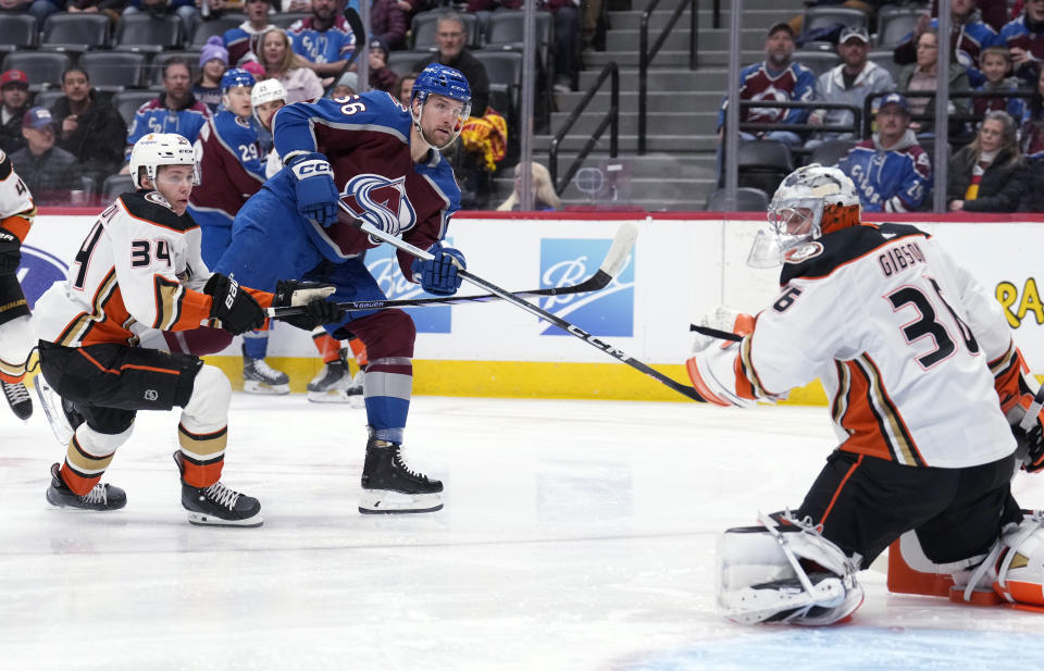 Colorado Avalanche defenseman Kurtis MacDermid, center, shoots the puck for a goal past Anaheim Ducks goaltender John Gibson, right, as defenseman Pavel Mintyukov covers during the first period of an NHL hockey game Tuesday, Dec. 5, 2023, in Denver. (AP Photo/David Zalubowski)