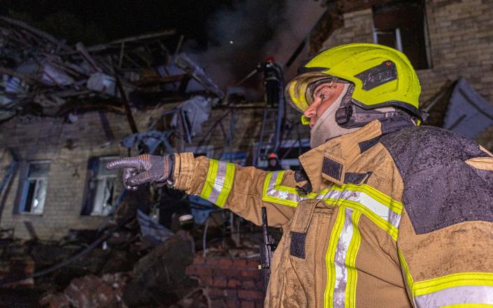 Rescuers work at a site of a building damaged by a Russian drone strike, amid Russia&#39;s attack on Ukraine, in Kharkiv, Ukraine