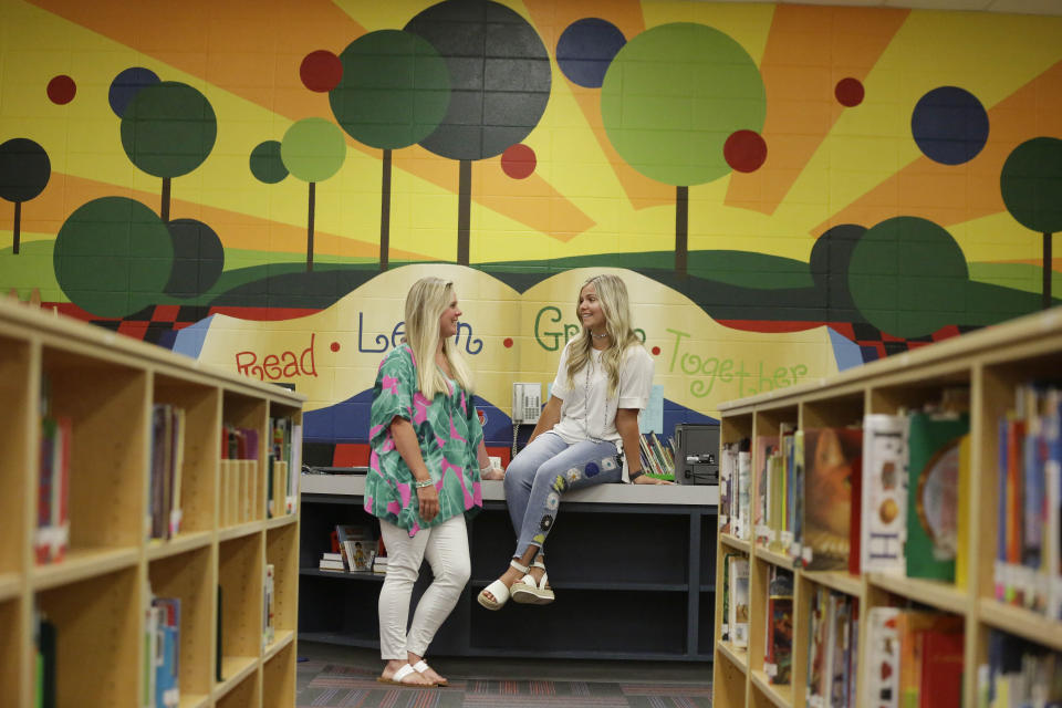 First grade teachers, Ellie Morgan, 25, left, Hannah Sprayberry, 28, right, pose for a portrait, and say they are taking around 5 per-cent pay cut on Thursday, May 28, 2020, in Fort Oglethorpe, Ga. With sharp declines in state spending projected because of the economic fallout from the COVID-19 pandemic, America's more than 13,000 local school systems are wrestling with the likelihood of big budget cuts. (AP Photo/Brynn Anderson)