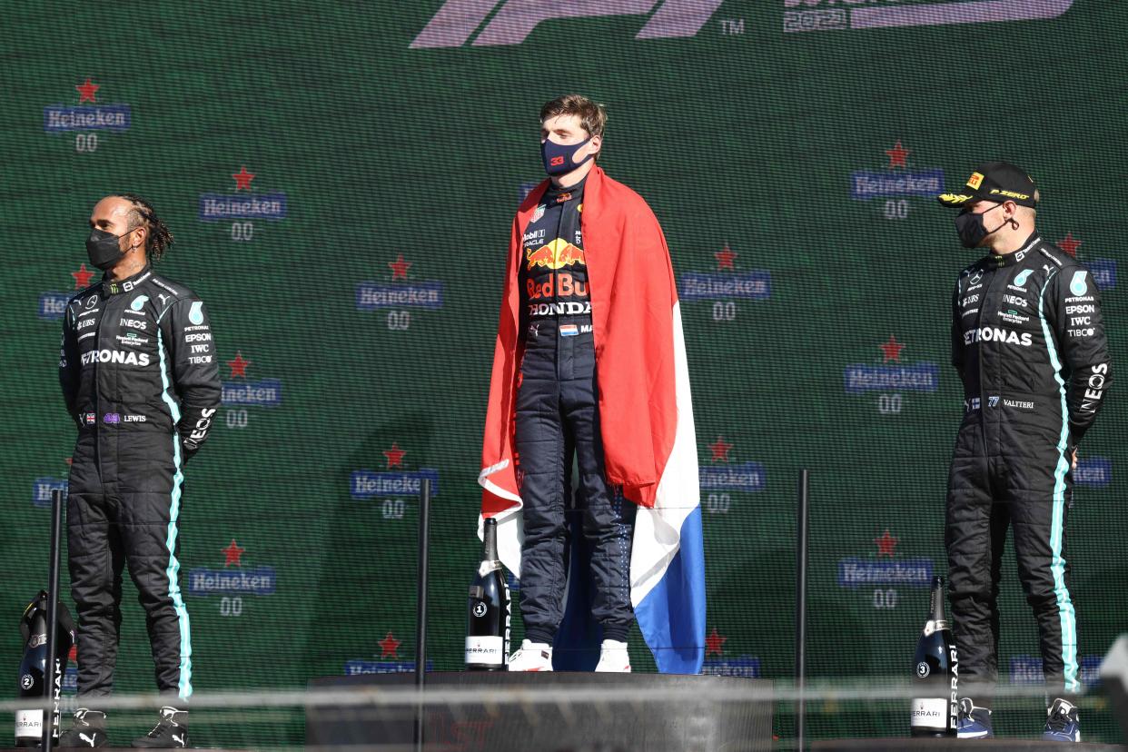 Max Verstappen (C), Lewis Hamilton and Valtteri Bottas stand on the podium.