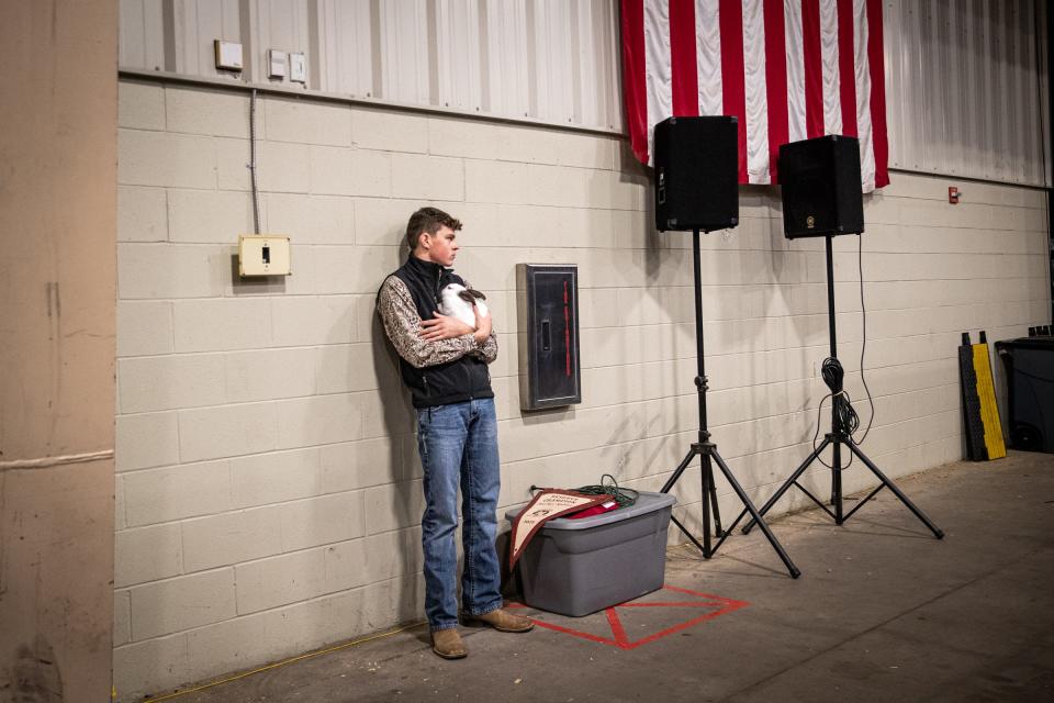 Jeremiah Hooper, 18, with Flour Bluff-Padre Island 4-H, calms on of his Reserve Grand Champion Market Rabbits while waiting backstage for the Nueces County Junior Livestock Show auction on Saturday, Jan. 21, 2023, in Robstown, Texas. 