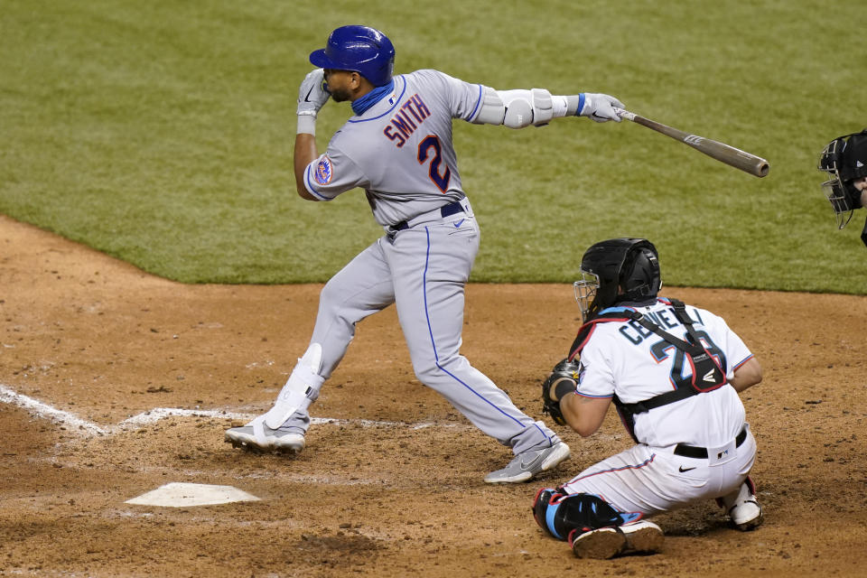 New York Mets' Dominic Smith (2) follows through on a double to score Michael Conforto as Miami Marlins catcher Francisco Cervelli (29) looks on during the eighth inning of a baseball game, Wednesday, Aug. 19, 2020, in Miami. (AP Photo/Lynne Sladky)