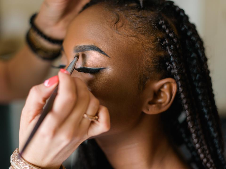 Makeup artist create look with bold brows on a client