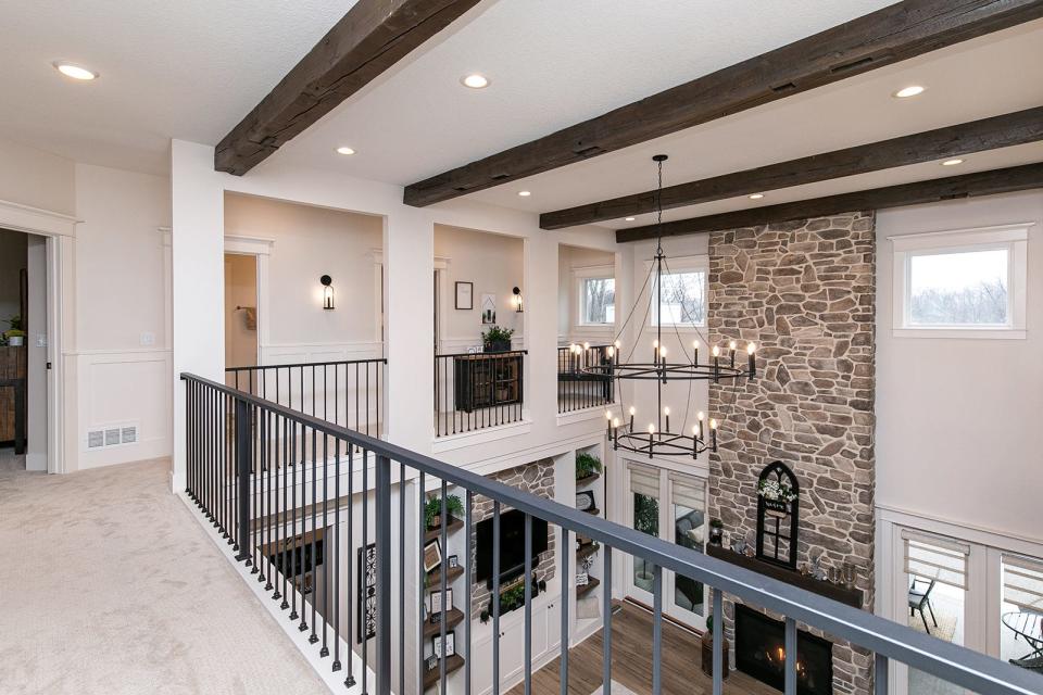 The family room spans two stories with a floor-to-ceiling stone fireplace.