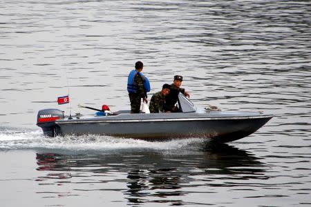 North Korean soldiers sit in a boat as they go down Yalu River between North Korea's Sinuiju and China's Dandong, Liaoning province, September 12, 2016. REUTERS/Thomas Peter