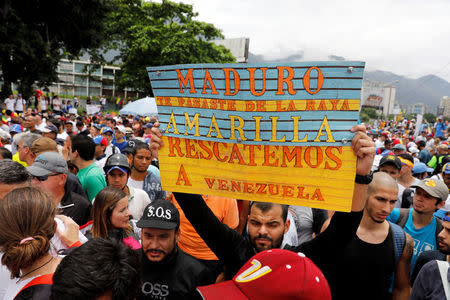 Opposition supporters with a sign that reads, "Maduro, you crossed the line. Let's rescue Venezuela", rally against President Nicolas Maduro in Caracas, Venezuela May 3, 2017. REUTERS/Carlos Garcia Rawlins