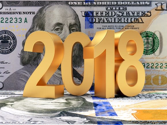 The numbers 2018 sit on top of and in front of a $100 bill.