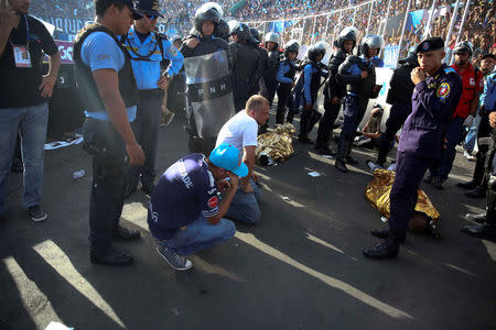 ATENCIÓN EDITORES- COBERTURA VISUAL DE ESCENAS DE HERIDOS O MUERTOS. Hombres reaccionan cerca de dos cadáveres luego de una estampida en el Estadio Nacional de Tegucigalpa, Honduras, 28 de mayo de 2017. Al menos cuatro personas murieron y más de 20 resultaron lesionadas el domingo en Honduras por una estampida de aficionados que pretendían ingresar a un estadio para presenciar la final de la liga de fútbol profesional local, dijeron cuerpos de socorro. REUTERS/Alberto Poveda FOR EDITORIAL USE ONLY. NO RESALES. NO ARCHIVES. TEMPLATE OUT. TPX IMAGES OF THE DAY