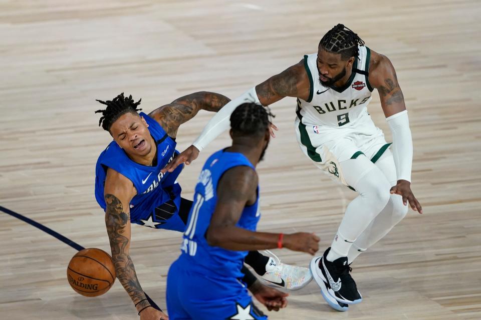 Orlando guard Markelle Fultz, left, and Milwaukee guard Wesley Matthews (9) scramble for a loose ball Thursday.