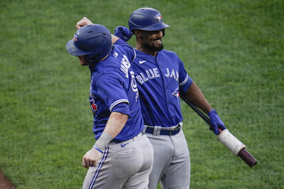 Toronto Blue Jays' Danny Jansen, left, is congratulated by Marcus Semien after hitting a two-run home run against the Baltimore Orioles during the fourth inning of the first game of a baseball doubleheader, Saturday, Sept. 11, 2021, in Baltimore. (AP Photo/Julio Cortez)