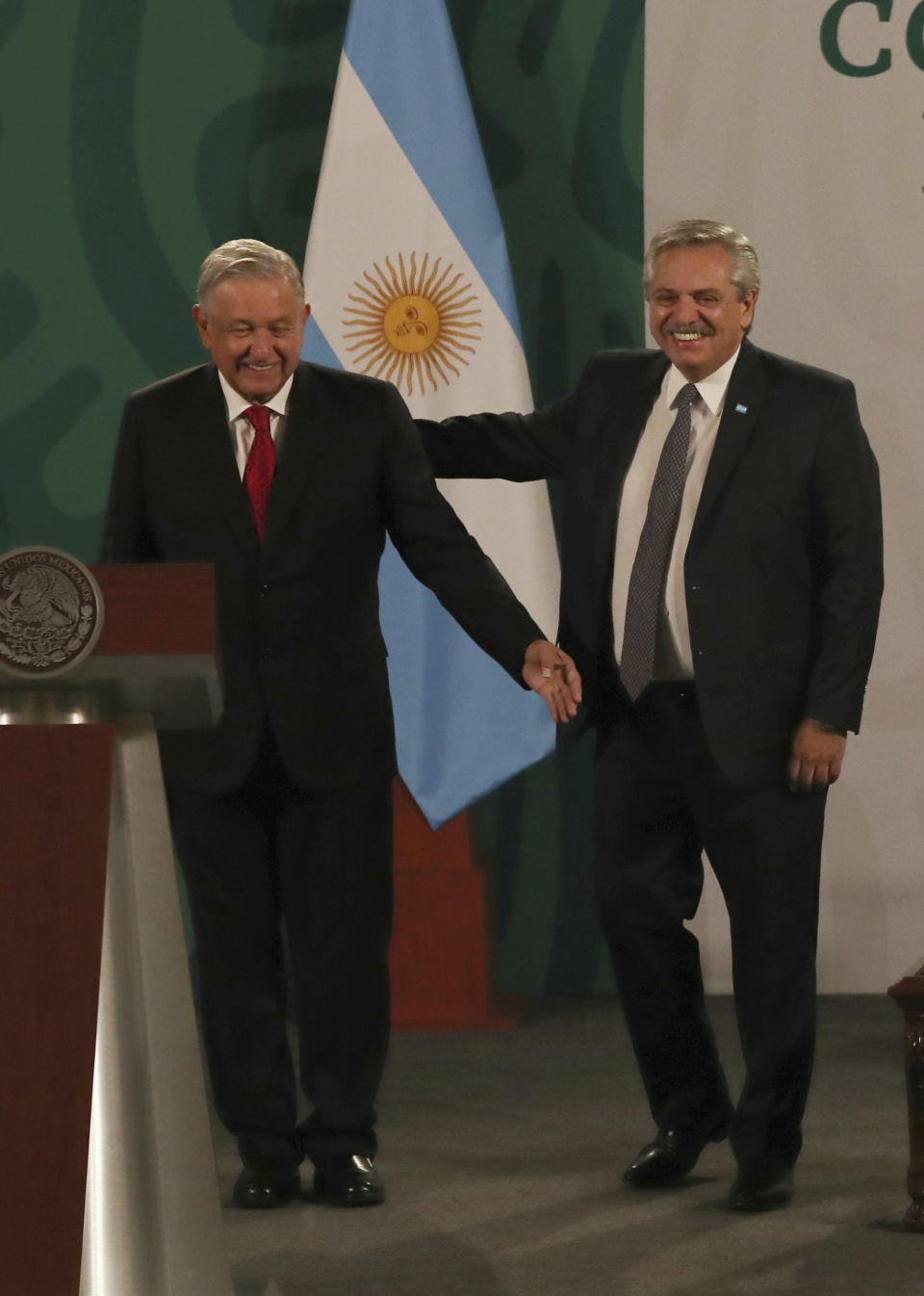 Argentina's President Alberto Fernández, right, arrives with Mexican President Andrés Manuel López Obrador for the Mexican president's daily, morning press conference at the National Palace in Mexico City, Tuesday, Feb. 23, 2021. Fernández is on a four-day official visit to Mexico. (AP Photo/Marco Ugarte)