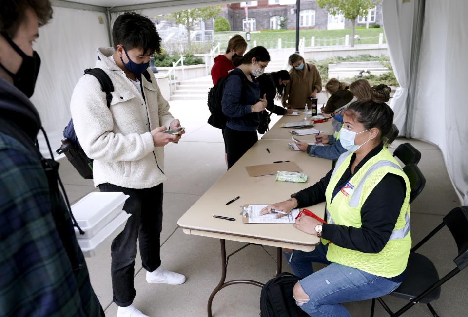 Elizabeth Quirmbach, right, registers Ayuka Sinanoglu, center, outside of University of Wisconsin-Madison's Memorial Union in Madison, Wis., on Oct. 19, 2020.