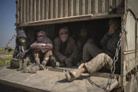 Men ride in the back of a truck that is part of a convoy evacuating hundreds out of the last territory held by Islamic State militants in Baghouz, eastern Syria, Wednesday, Feb. 20, 2019. The evacuation signals the end of a week long standoff and opens the way to U.S.-backed Syrian Democratic Forces (SDF) recapture the territory. (AP Photo/Felipe Dana)