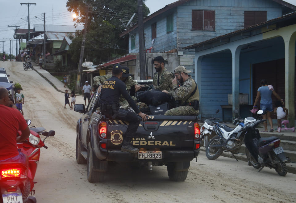 Federal police officers ride on the back of a truck carrying items found during a search for Indigenous expert Bruno Pereira and freelance British journalist Dom Phillips in Atalaia do Norte, Amazonas state, Brazil, Sunday, June 12, 2022. Divers from Brazil's firefighters corps found a backpack and laptop Sunday in the remote Amazon area where Pereira and Phillips went missing a week ago, firefighters said. (AP Photo/Edmar Barros)