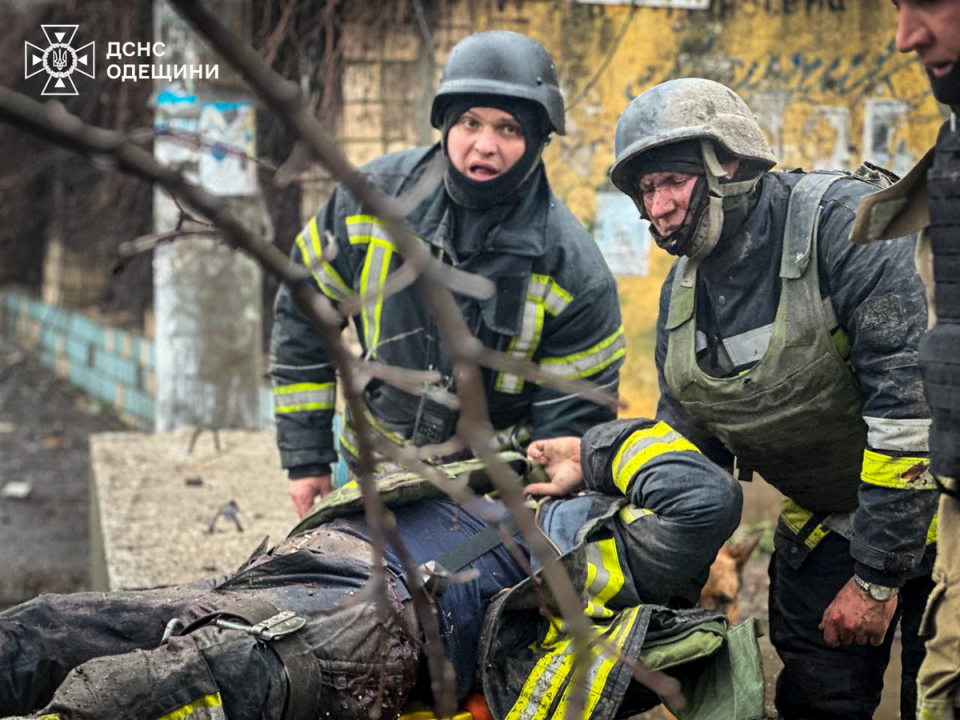 Rescuers carry an injured colleague (via REUTERS)