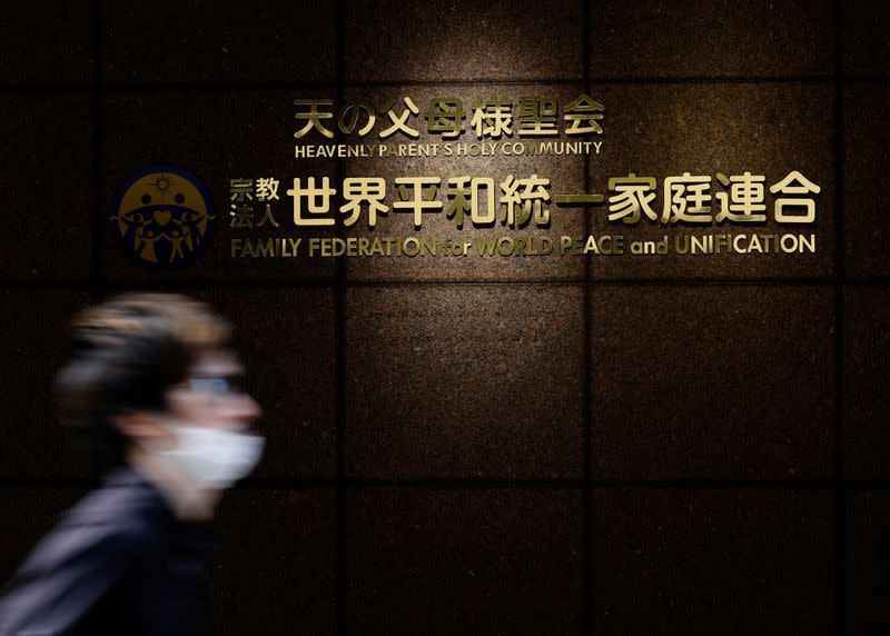 A person walks past the sign of Family Federation for World Peace and Unification in Tokyo