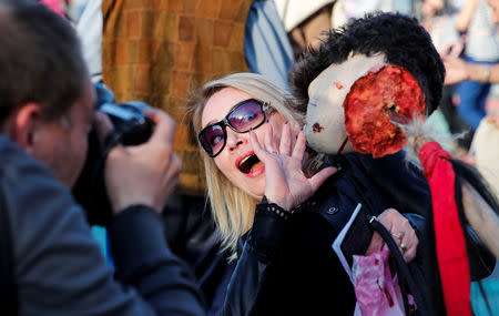 A photographer takes a picture of woman scared of fake severed head before the screening of final episode of Game of Thrones on 20-meter-high screen at RZD Arena in Moscow, Russia May 20, 2019. REUTERS/Maxim Shemetov
