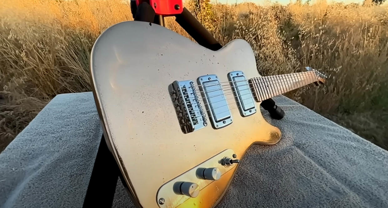  Burls Art Copper Bronze Guitar, glinting in the sunlight. 