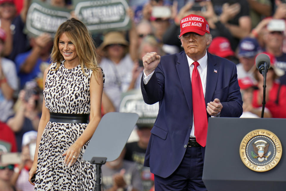 President Donald Trump pumps his fist as first lady Melania Trump smiles at supporters after a campaign rally Thursday, Oct. 29, 2020, in Tampa, Fla. (AP Photo/Chris O'Meara)