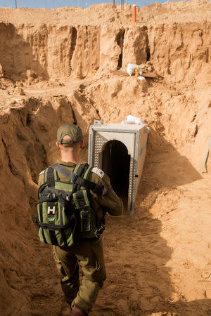 An Israeli soldier stands next to an entrance to what the Israeli military say is a cross-border attack tunnel dug from Gaza to Israel, on the Israeli side of the Gaza Strip border near Kissufim January 18, 2018. REUTERS/Jack Guez/Pool