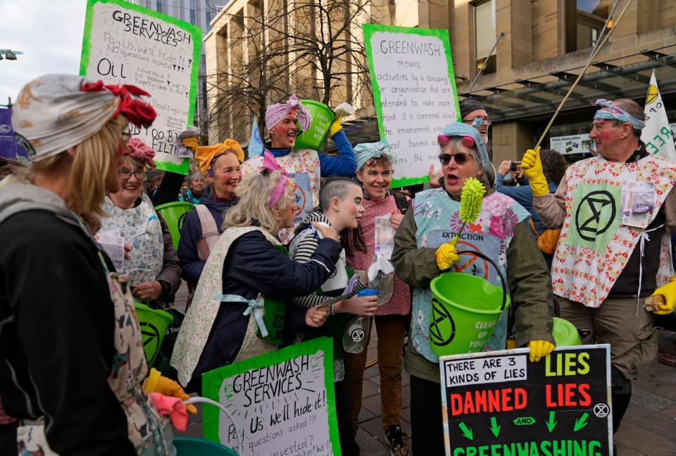 Activists take part in a demonstration against greenwashing at a climate summit in Glasgow 2021.