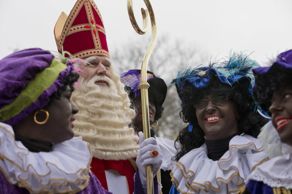 In this Saturday Nov. 16, 2013, file photo Sinterklaas, the Dutch version of Santa Claus, and "Zwarte Piet", or "Black Pete" arrive in Hoorn, north-western Netherlands. As many Dutch children eagerly anticipate the arrival of their country's version of Santa Claus this weekend, opponents and supporters of his controversial helper Black Pete are gearing up for protests. Black Pete is often played by white people with their faces daubed in dark makeup. Supporters see him as a traditional children's character, while opponents decry him as a racist stereotype. (AP Photo/Peter Dejong)