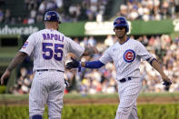 CORRECTS PITCHER'S NAME TO BRYSE WILSON FROM DILLON PETERS - Chicago Cubs first base coach Mike Napoli greets Andrelton Simmons at first after Simmons' first hits as a Cub, an RBI single off Pittsburgh Pirates relief pitcher Bryse Wilson during the first inning of a baseball game Monday, May 16, 2022, in Chicago. (AP Photo/Charles Rex Arbogast)