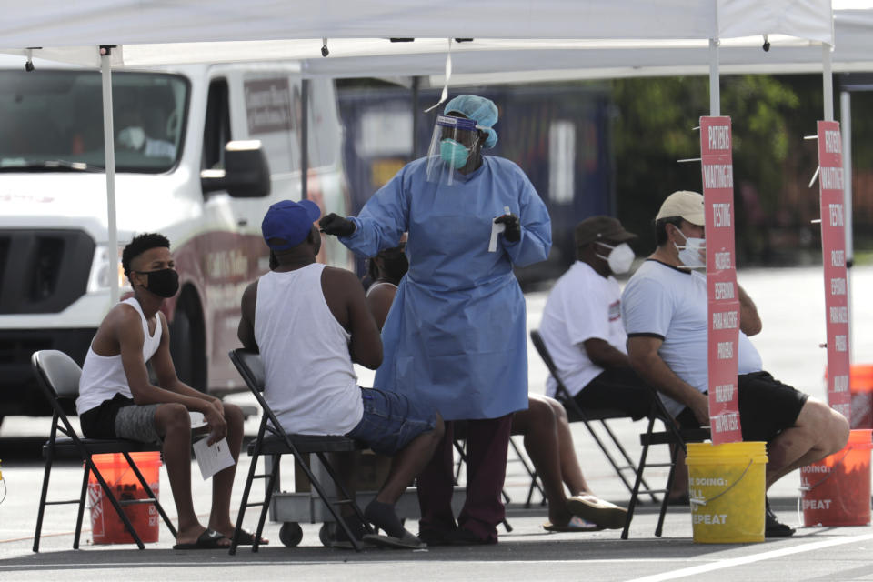 A health care worker administers a COVID-19 test at a site sponsored by Community Heath of South Florida at the Martin Luther King, Jr. Clinica Campesina Health Center, during the coronavirus pandemic, Monday, July 6, 2020, in Homestead, Fla. (AP Photo/Lynne Sladky)