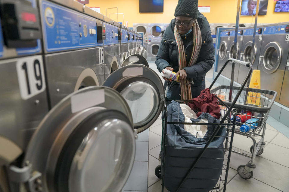 Kassi Keith prepares to disinfect a washing machine before using it for her clothes at a laundromat near the hotel she lives in, Wednesday, March 8, 2023, in the Brooklyn borough of New York. Around Manhattan and elsewhere in the city, hotels that served tourists just a few years ago have become de facto emergency shelters. The latest is the historic Roosevelt Hotel in midtown Manhattan, which shuttered three years ago, is reopening later this week as a welcome center and shelter for asylum seekers. (AP Photo/Mary Altaffer)