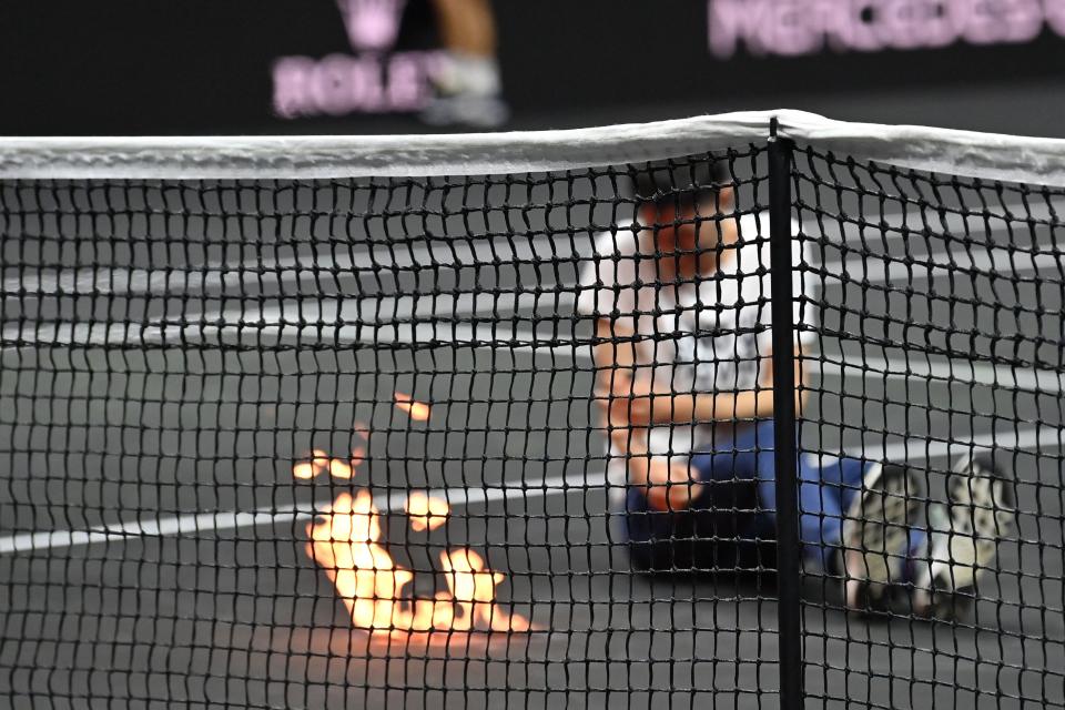 A protester, pictured here setting his arm and the court on fire at the Laver Cup.