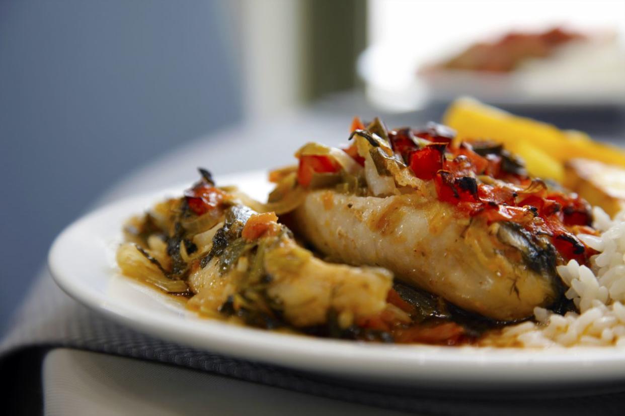 Close up of baked fish on white plate