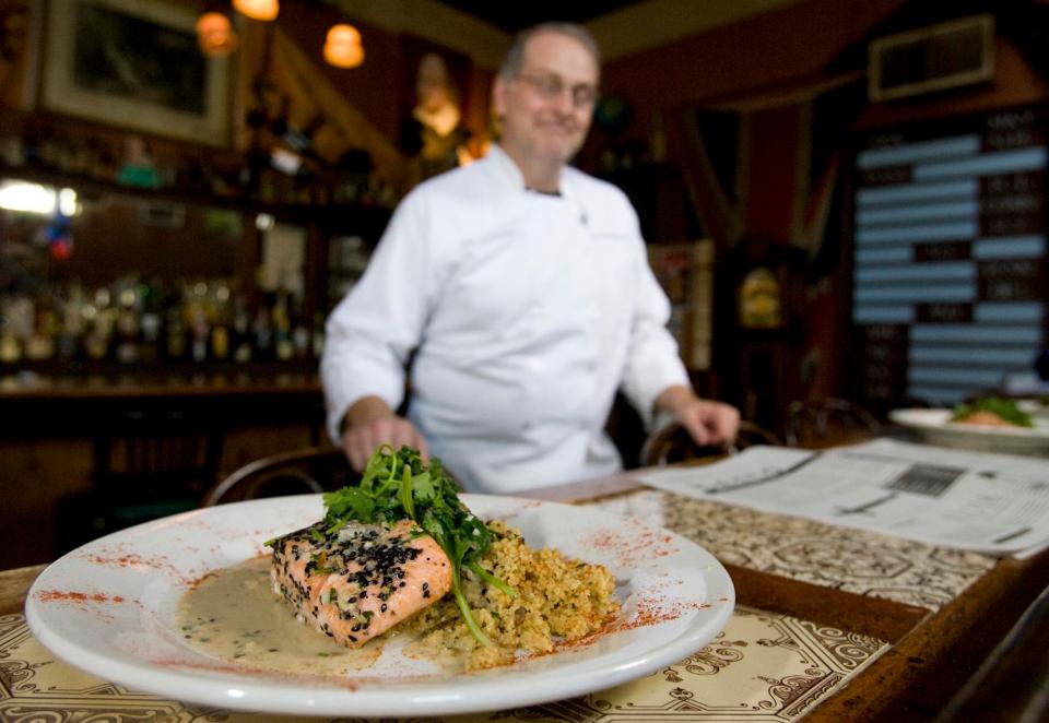 Jeff Wilson prepares a meal of oriental salmon with wilted greens and coconut reduction sauce served with couscous and greens at The Globe restaurant in Northport in this Aug. 19, 2008, file photo.