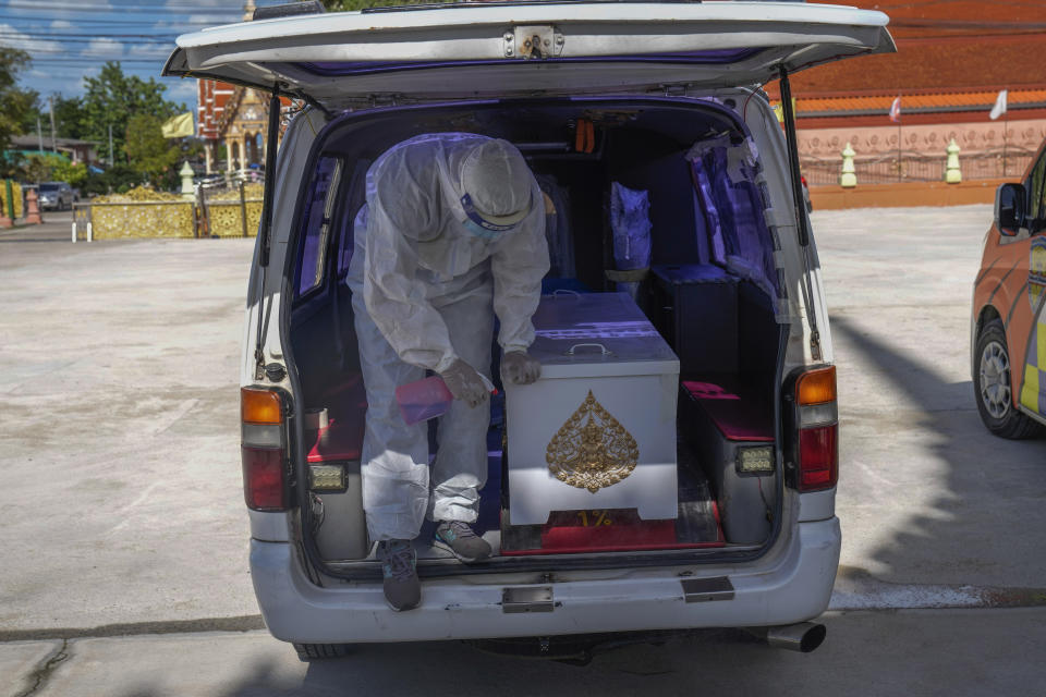 A Siam Nonthaburi Foundation volunteer in full a protective suit sprays disinfect on a coffin containing a COVID-19 victim for a free funeral ceremony service at Wat Ratprakongtham temple Nonthaburi Province, Thailand, Monday, July 12, 2021. Wat Ratprakongtham temple offering free funeral service for people dying from COVID-19 says it is struggling to keep up with 24-hour cremation, and is adding another crematorium as Thailand sees a growing number of cases and deaths in a coronavirus surge that began in early April. (AP Photo/Sakchai Lalit)