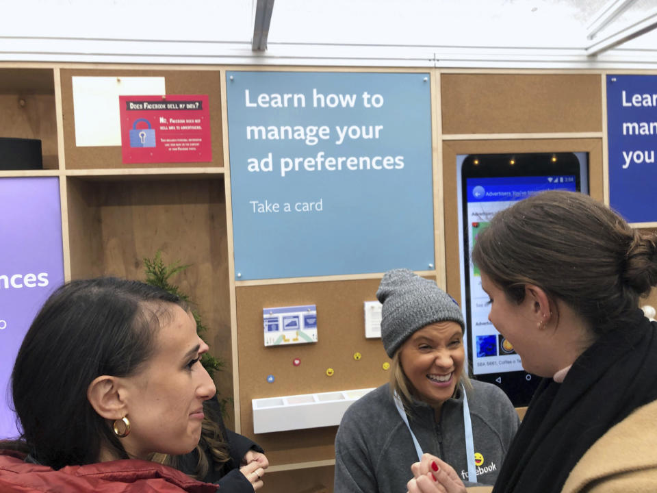 People talk inside a Facebook “pop-up” trailer in New York’s Bryan Park on Thursday, Dec. 13, 2018. The company hosted a one-day event open to the public, with Facebook employees on hand to answer questions about privacy settings and other issues. The pop-up event caps a difficult year for the company.(AP Photo/Barbara Ortutay)