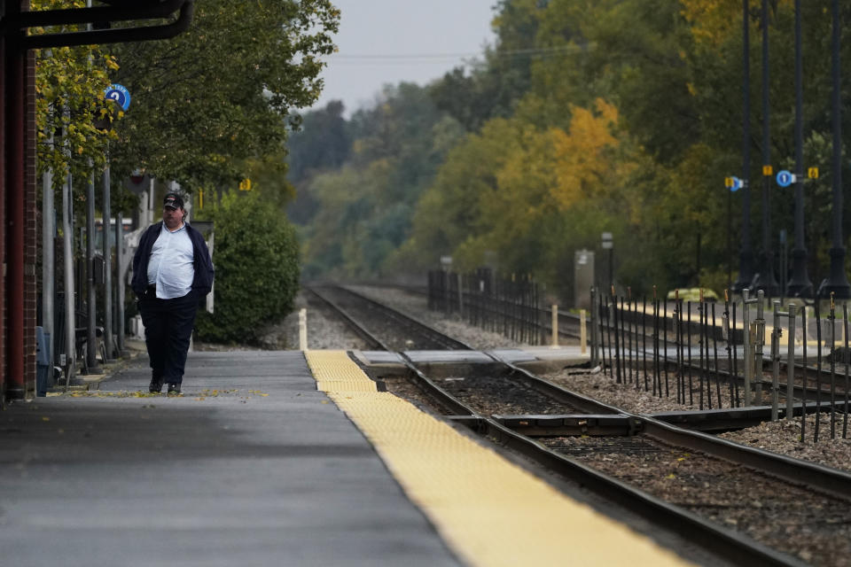 A passenger waits for a train at a Metra station in Northbrook, Ill., Wednesday, Oct. 12, 2022. A fifth rail union has approved its deal with the freight railroads to secure 24% raises and $5,000 in bonuses and a sixth one is set to vote Thursday. But all 12 rail unions must ratify their contracts to prevent a strike. (AP Photo/Nam Y. Huh)