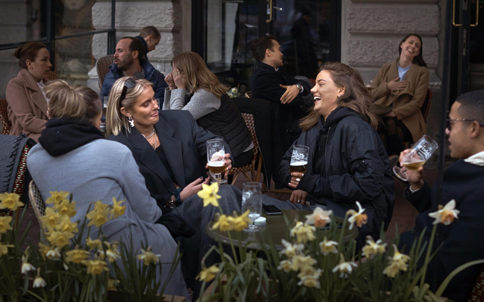 People chat and drink outside a bar in Stockholm, Sweden. Source: AP