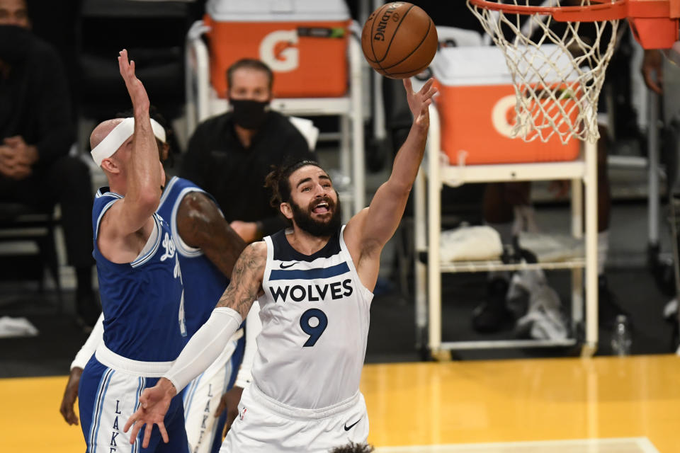 Minnesota Timberwolves guard Ricky Rubio (9) shoots past Los Angeles Lakers guard Alex Caruso during the first half of an NBA basketball game in Los Angeles, Sunday, Dec. 27, 2020. (AP Photo/Kyusung Gong)