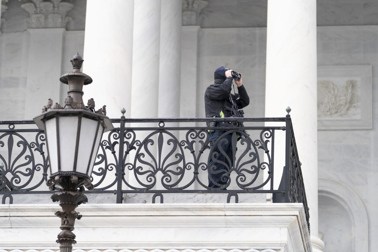 A U.S. Capitol Police officer checks outside of the Capitol building, Tuesday, March 1, 2022, in Washington. President Joe Biden will deliver his first State of the Union address at a precipitous moment for the nation. Biden is aiming to navigate the country out of a pandemic, reboot his stalled domestic agenda and confront Russia's aggression. (AP Photo/Mariam Zuhaib)