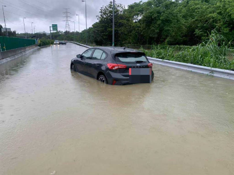 高雄市義大醫院往國道10號方向路面積水，積水高度約半個輪胎高以上，一名29歲的孕婦上午9時40分開車行經，造成車子拋錨，受困車內，緊急求救110。(圖／高雄市警方提供／中國時報林雅惠傳真)